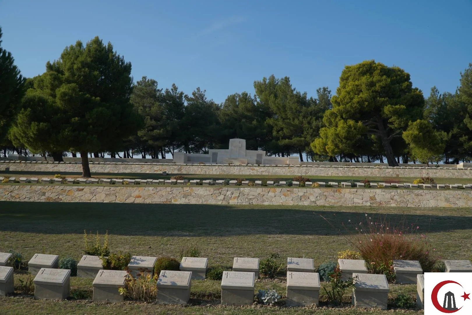 Twelve Tree Copse Mezarlığı içinde yükselen beyaz taş mimarili Yeni Zelanda Ulusal Anıtı